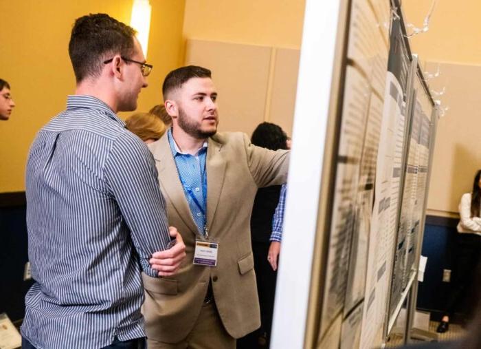 Two individual having a conversation during the annual Research Symposium.