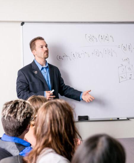 Male faculty member speaking to class.