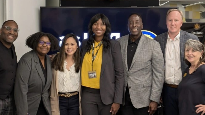 A group of people in business attire standing shoulder to shoulder for a photo.